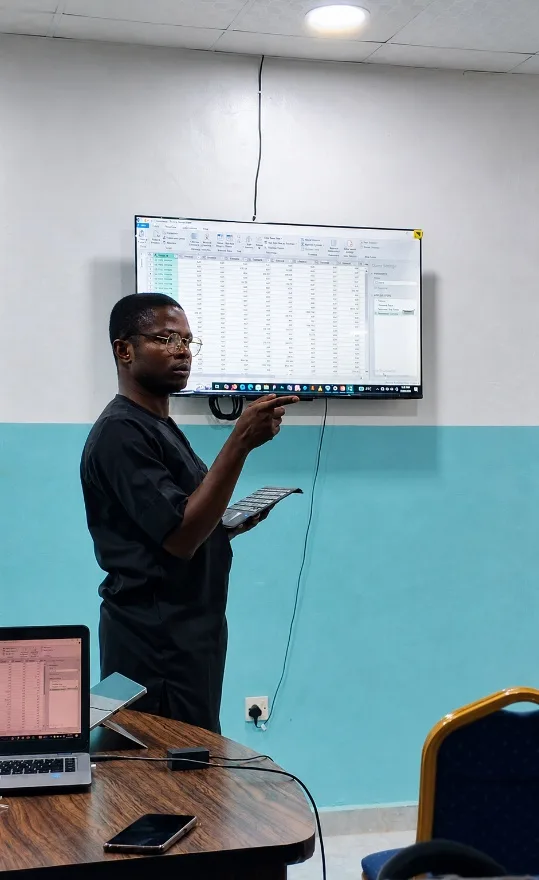 Enoch teaching Power Query at the front of a classroom
